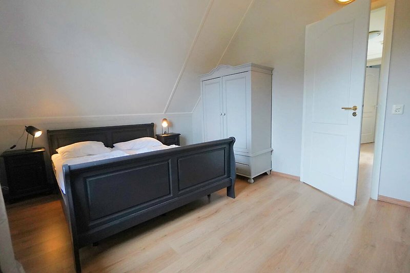 Holzhaus mit gemütlichem Schlafzimmer und stilvoller Beleuchtung.