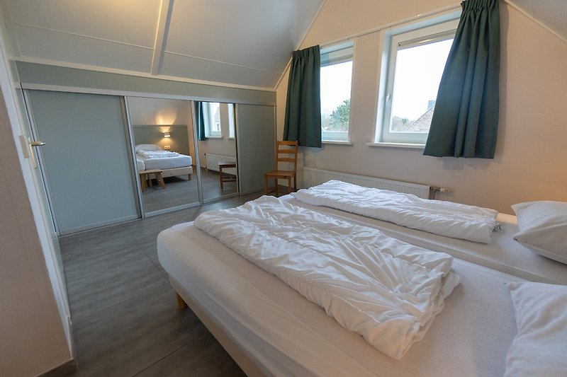 Stilvolles Schlafzimmer mit elegantem Bett und Fenster.