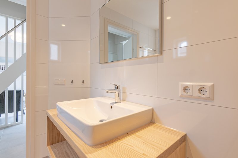 Moderne badkamer met stijlvolle wastafel en glazen douchewand.