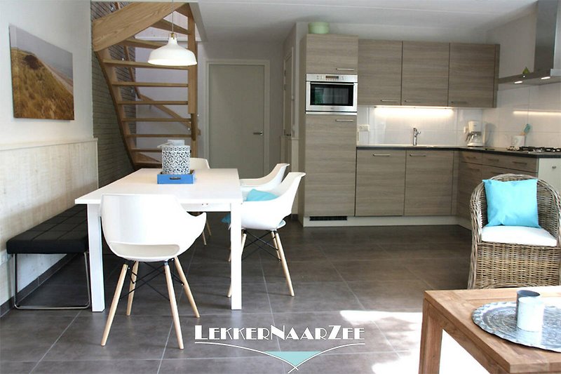 Moderne Einrichtung mit Holzmöbeln, blauer Couch und Küchentisch. Gemütliche Atmosphäre.