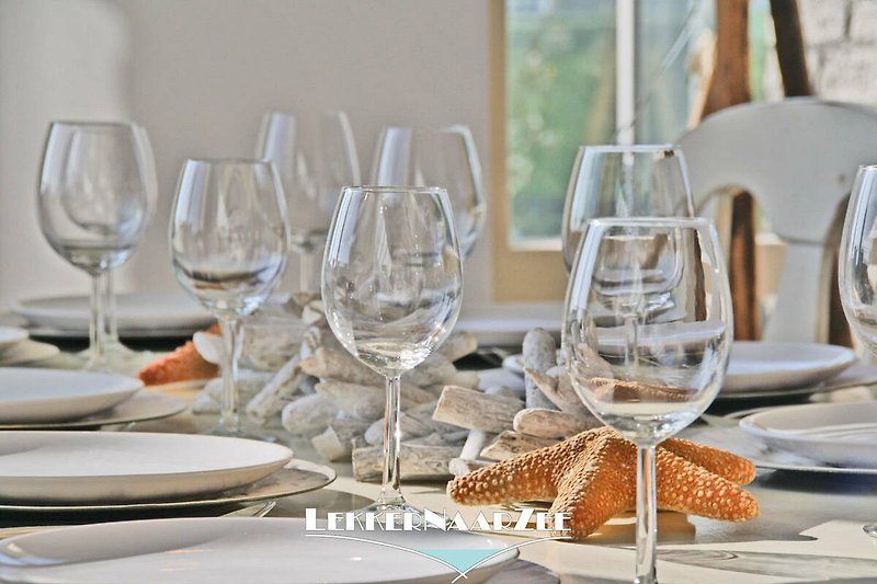 Elegante Tischdekoration mit Geschirr, Gläsern und Besteck.