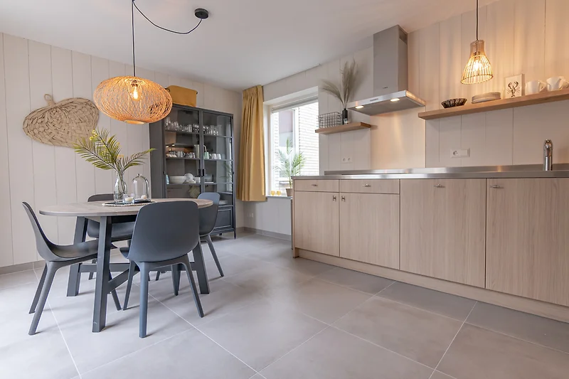 Moderne keuken met grijze kasten en houten meubels.
