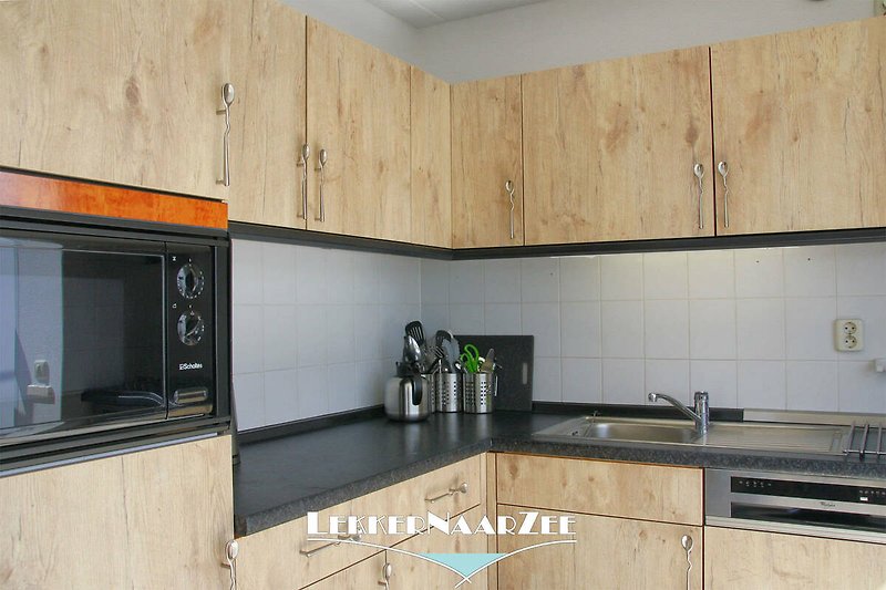 Moderne Küche mit Holzschränken, Granitarbeitsplatte und Gasherd.