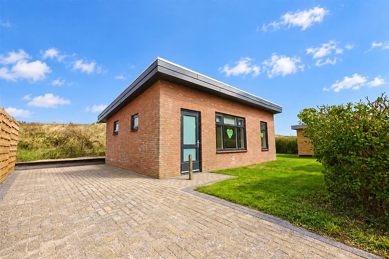 Hofansicht mit Grasfläche und Zufahrt am Bauernhaus.