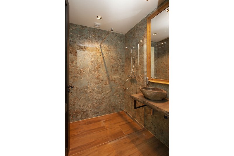 Stilvolles Badezimmer mit Holzboden und modernen Armaturen.