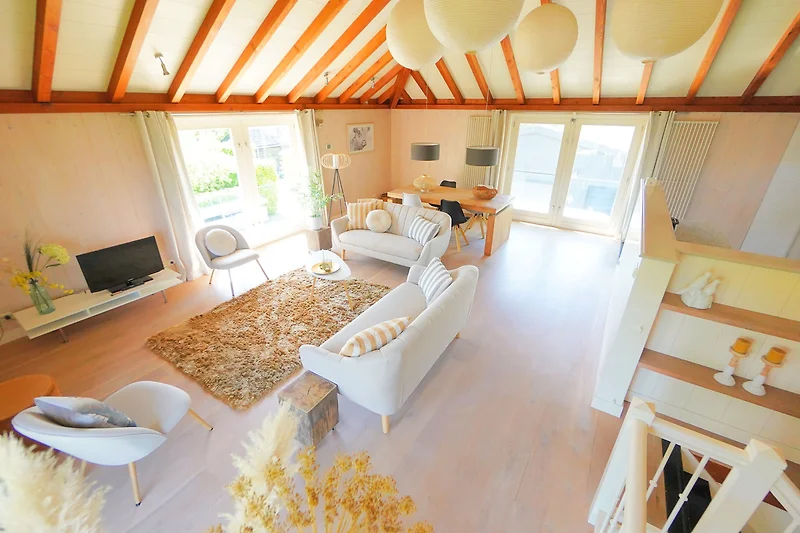 Wohnzimmer mit Holzbalken, Tagesbett und stilvoller Beleuchtung.