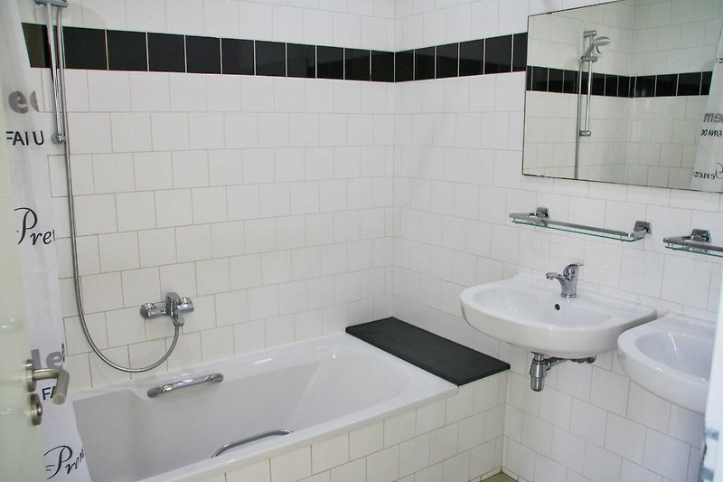 Modernes Badezimmer mit schwarzer Badewanne und Waschbecken.