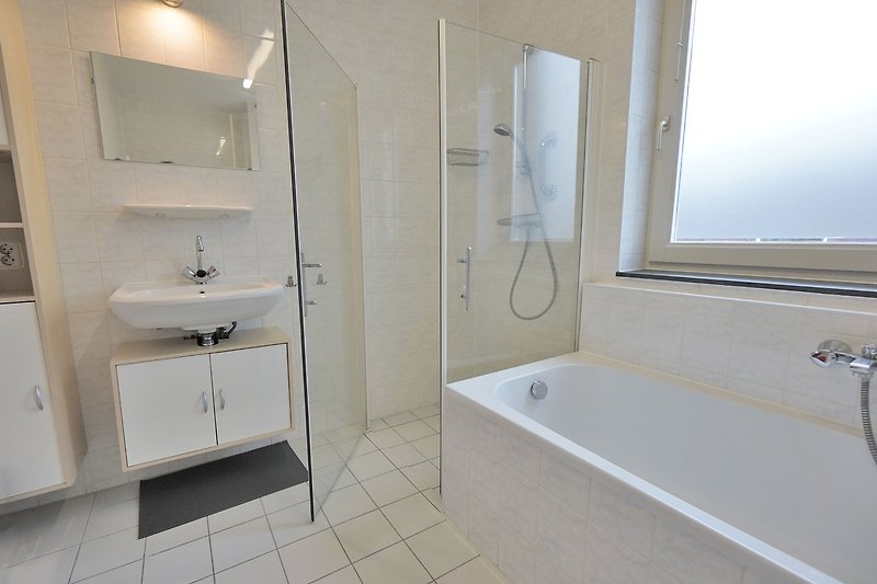 Modernes Badezimmer mit eleganten Armaturen und geräumigem Spiegel.