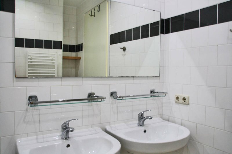 Badezimmer mit modernem Waschbecken und Spiegel.
