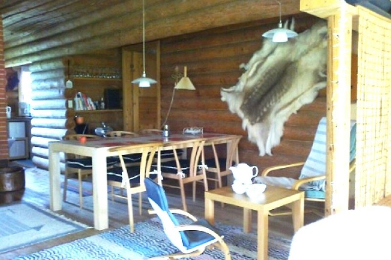Holzhaus mit rustikalen Möbeln und Tisch im Freien. Gemütliche Atmosphäre.