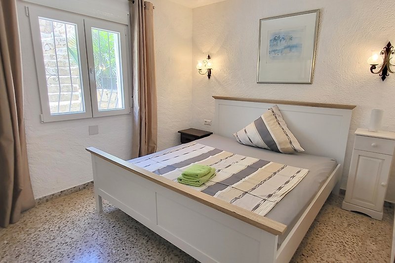 Schlafzimmer mit Holzmöbeln, Bett und Fenster - perfekt für Ihren Urlaub!