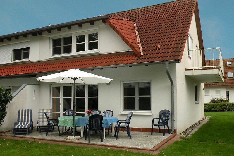 Das Ferienhaus mit Sonnenterrasse und Gartenmöbeln.