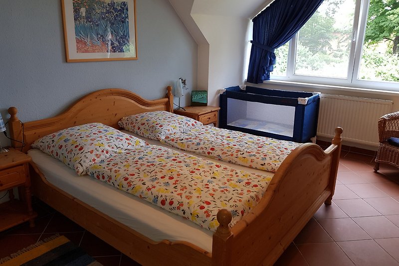 Ein Schlafzimmer mit Doppelbett und Babybettchen