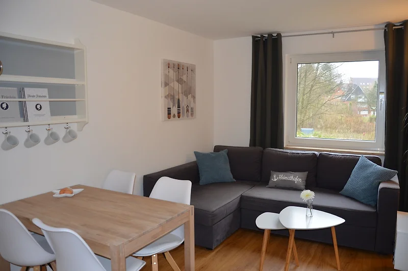 Woonruimte met eettafel en slaapbank.