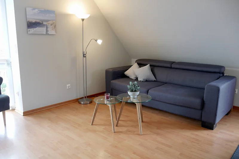 Knusse woonkamer met houten details en een comfortabele bank.