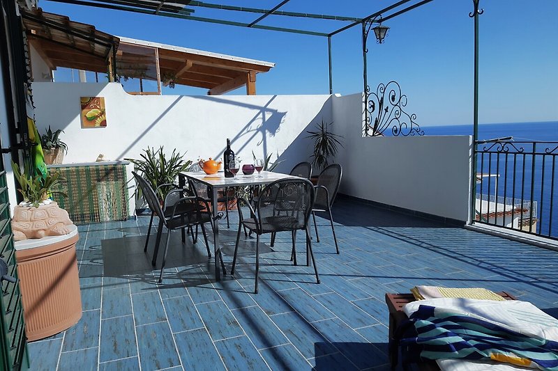 Genießen Sie die Aussicht auf das azurblaue Wasser und entspannen Sie sich im Freien auf der Terrasse.