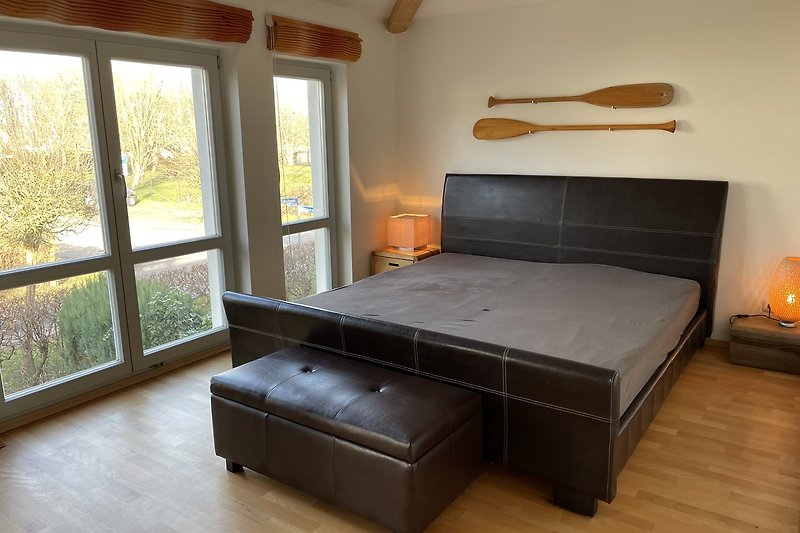 Holzinterieur mit bequemem Bett und Fensterblick.