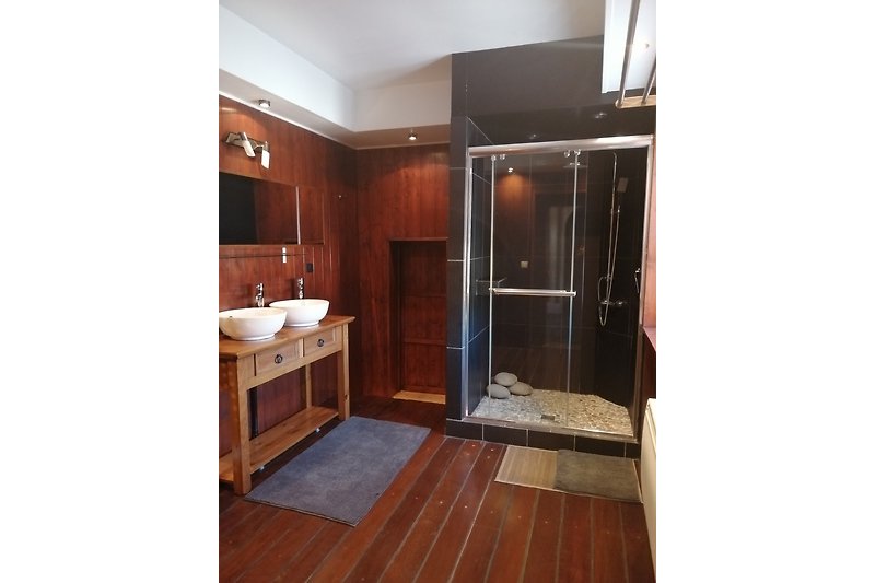 Schönes Badezimmer mit Holzboden und moderner Einrichtung.