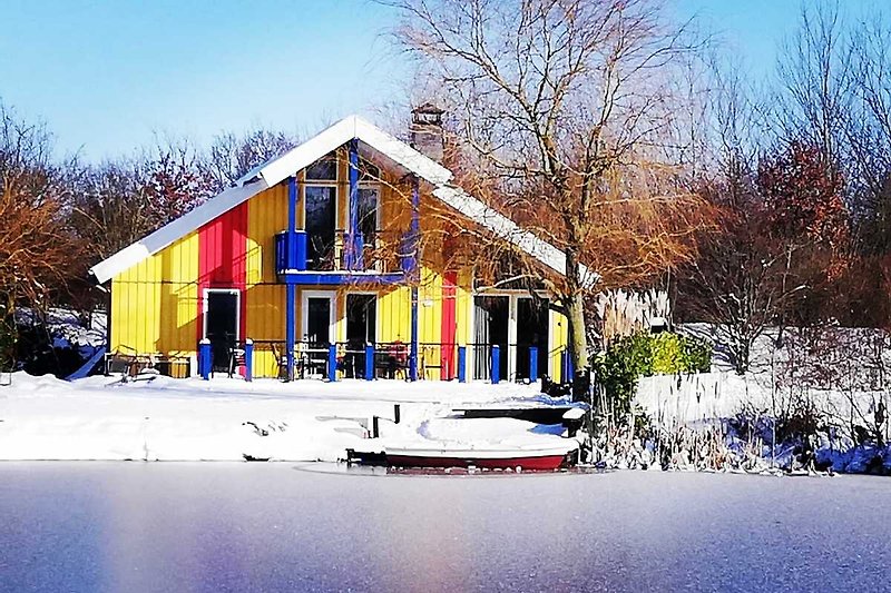 Gemütliches Ferienhaus mit verschneitem Dach und malerischem Winterblick.