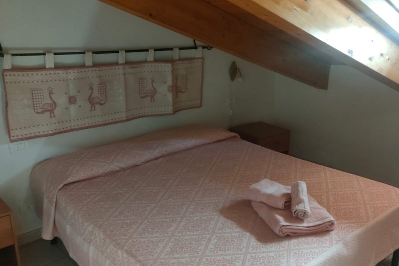 Schlafzimmer mit gemütlichem Bett und Holzmöbeln.