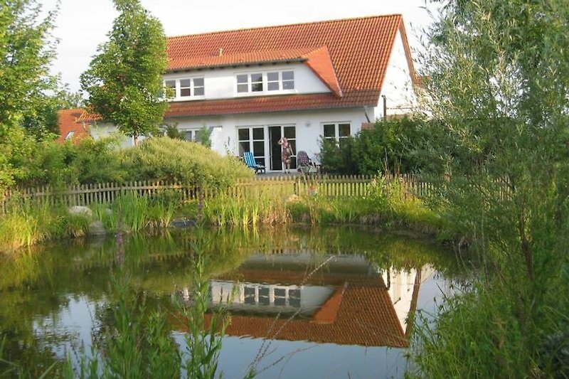 Haus, Grundstück mit umzäunten Teich