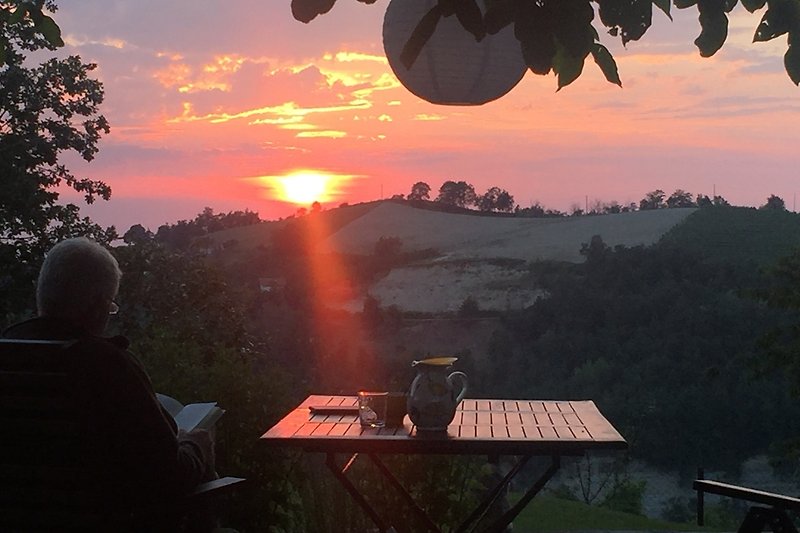 Genießen Sie den Sonnenuntergang am Tisch im Freien.