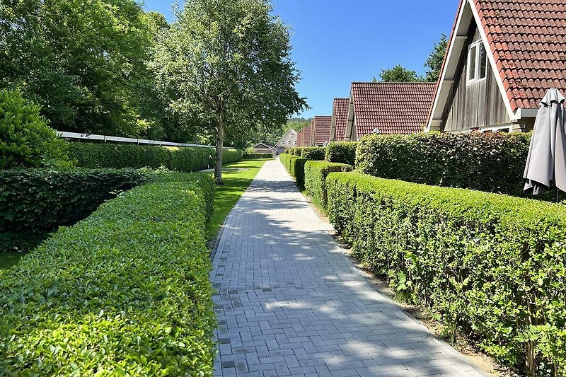 Ländliche Villa mit gepflegtem Garten und Ziegelpflasterweg.