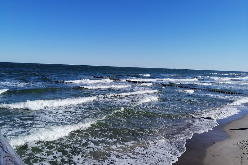 Verbringen Sie Ihren Urlaub an diesem ruhigen Strand mit klarem Wasser und weitem Horizont. Entspannen Sie sich und genießen Sie die Meeresbrise.