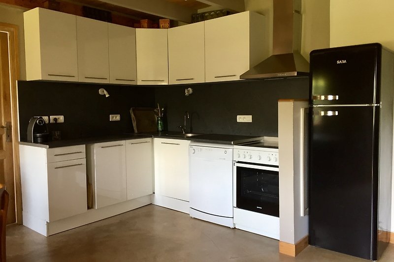 Une cuisine moderne avec des armoires en bois, un comptoir en granit et des appareils électroménagers en acier inoxydable.