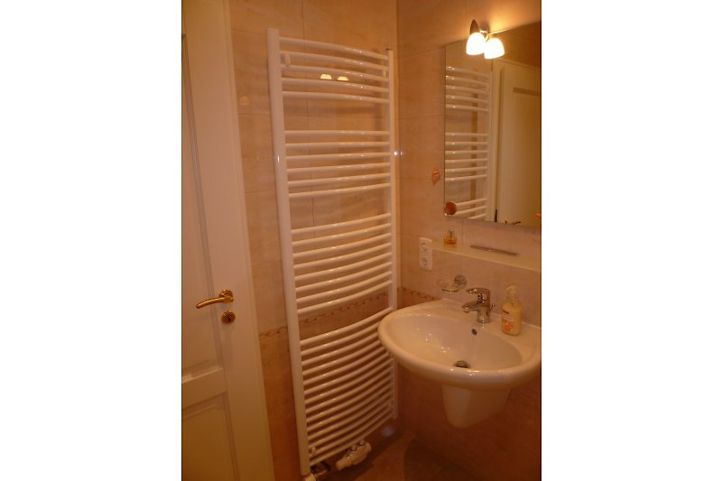 Badkamer op de woonverdieping met wastafel, vloerverwarming, handdoekverwarmer, buitenraam (niet zichtbaar)
