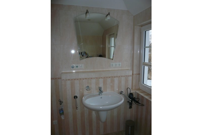 Bathroom on the sleeping floor - sink, shaving mirror, bathroom radio, hairdryer, the outside window on the right.